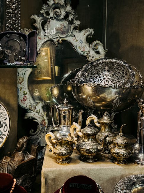 A person with a checkered blazer is holding an ornate black and gold porcelain vase with floral decorations and gold handles during a home relocation or moving process. The vase is small and delicate,